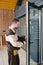 A man standing in front of a glass door while repairing lock