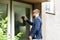 Man Standing In Front Of The House Knocking The Door