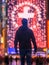 Man standing in front of an illuminated cross in times square