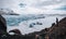 A man standing in front of a massive blue glacier at Solheimajokull and Vatnajokull and Svinasfellsjokull glacier in