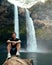 Man standing in front of Wailua Waterfall on Kauai, Hawaii.