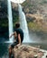 Man standing in front of Wailua Waterfall on Kauai, Hawaii.