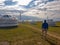 A man standing in front of white, traditional yurts located on a pasture in Xilinhot in Inner Mongolia. Endless grassland