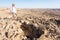 Man standing grave looking at desert crater moutains landscape.