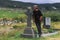 Man standing by grave marker in Kilcatherine Church cemetery, Cork, Ireland