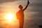 A man standing on a hill looking link on the background of a beautiful sunset