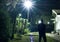 Man standing on a lawn looking at the stars in the night sky during a cold winter night. long exposure shot of a man.