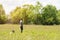 Man standing in the meadow with a boomerang in his hand