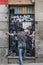 A man standing in a metal door with some painted graffiti