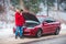 man standing near broken car with opened hood calling help