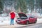 man standing near broken car with opened hood calling help