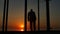 Man standing near glass doors of the house at sunset