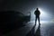 A man standing next to a car, with door open, parked on the side of the road, underneath a street light. On a foggy winters night