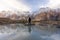 A man standing at Passu Cathedral valley and reflection on water in Northern Pakistan