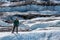 Man standing on a rib of white ice among many crevasses on the Matanuska Glacier
