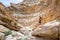 Man standing rock inside desert canyon.