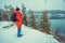 A man standing on the rocky lakeshore in winter