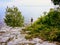 A man standing by the shore of Lake Ontario in Oakville, Ontari, Canada, staring out at the vast waters of the great lake