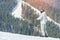 Man standing on skis on a snowy slope. Mountains in the background