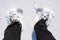 Man standing in the snow, closeup of a foot in a shoe from above.