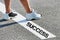 Man standing on stepping on white line with success sign