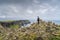 Man standing between stone stackings and admiring view on in iconic Cliffs of Moher, Ireland