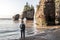 Man standing at Sunrise famous Hopewell Rocks formations at low tide biggest tidal wave Fundy Bay New Brunswick Canada