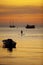 Man standing on sup ,stand up paddle board sailing in koh tao harbor against beautiful sunset sky