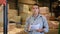 Man standing in warehouse and verifying documents with the presence of goods in the warehouse of industrial goods