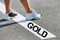 Man standing on white line with gold winner sign