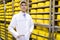 Man stands on the background of racks of cheese at the dairy plant