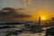 A man stands on the beach at sunset