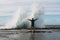Man stands in front of splashing wave