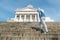 Man stands on the granite stairs at the Cathedral on the Senate