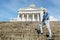 Man stands on the granite stairs at the Cathedral on the Senate