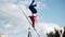 The man stands on his head on a rope stretched above the ground. Cool shots of performing tricks.