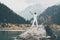 A man stands on a large stone and raises his hands to the sky. Snowy peaks of the mountains. , Issyk city, Kazakhstan