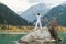 A man stands on a large stone and raises his hands to the sky. Snowy peaks of the mountains. , Issyk city, Kazakhstan