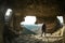 Man stands near a huge hole in the wall in cave in Crimea