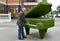 The man stands near a topiarny sculpture Grand piano. Svetlogorsk, Kaliningrad region