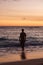 a man stands on the ocean at sunset in bali