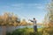 Man stands on the shore with a fishing rod. Angler in a jacket with a fishing rod stands on the river bank