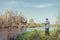 Man stands on the shore with a fishing rod. Angler in a jacket with a fishing rod stands on the river bank