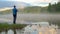 Man stands on stone against spreading fog over calm water