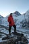 Man stands on the top of Kala Patthar mountain with blurred Mt. Everest in the background