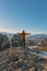 A man stands on top of a rocky mountains and enjoys the beautiful view of Meteora Monastery in Greece