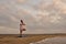 Man stands in tree pose asana at beach