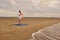 Man stands in tree pose asana at beach