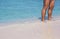 A man stands in the warm sandy beach in front of the blue sea