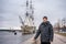 A man stands on the waterfront against the background of the ship on the Neva